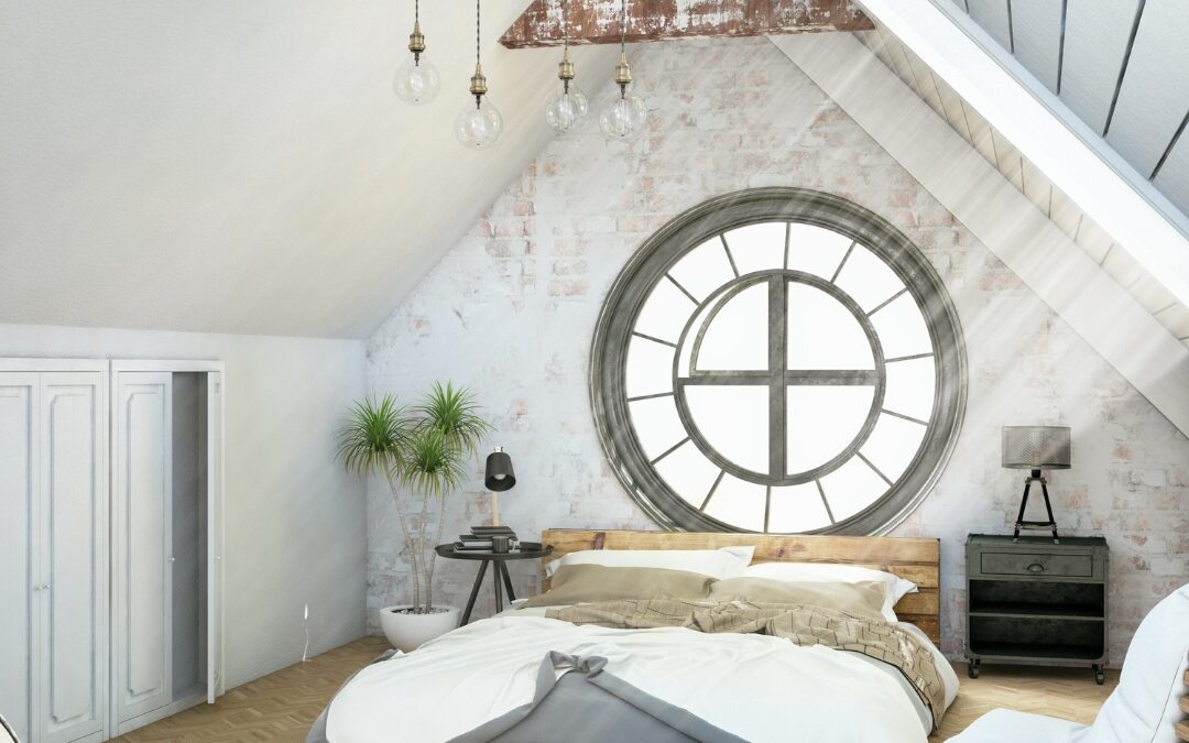 Attic bedroom conversion in Berlin CT with exposed beams, round window, and modern rustic design by Central Connecticut Building and Remodeling.